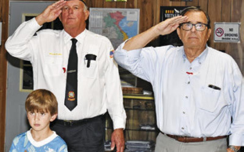 VETERANS AND YOUTH attending the Memorial Day service pay honor to America with the playing of the National Anthem.