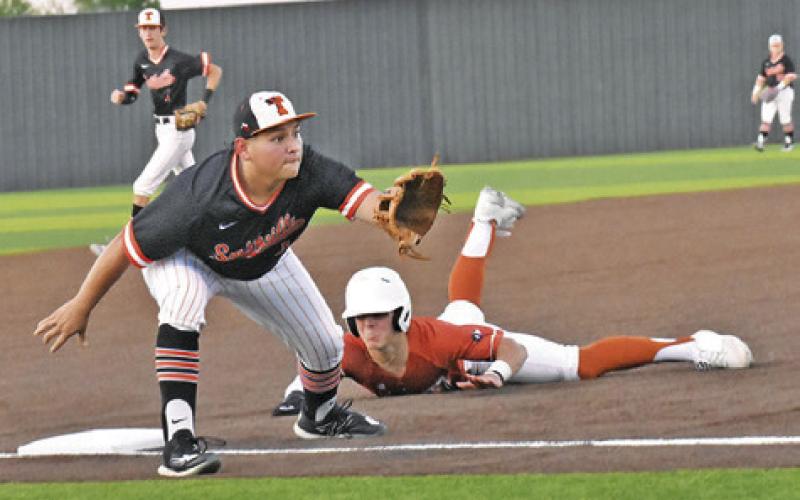 BLANE GARZA OF Caldwell slides into third base against Smithville last Friday. -- Tribune photo by Roy Sanders
