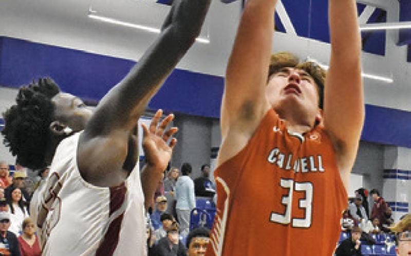KOY MACIK leaps high for this rebound against A&amp;amp;M Consolidated JV. Tribune photo by Roy Sanders