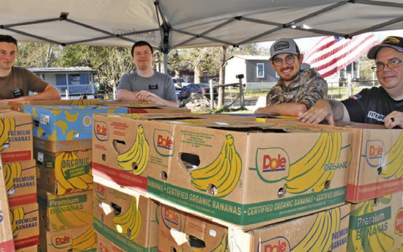 IN GOD’S HANDS Ministry prepares these food boxes on Saturday, Nov. 22, for distribution. Pictured are, from left, Drew Davidson, Joshua Thornton, Steven Joodin and David Palicka.