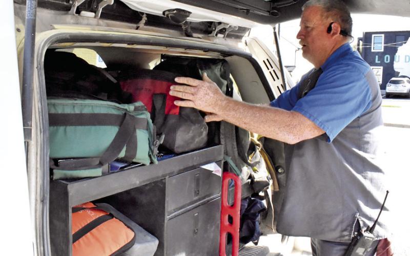 CALDWELL AND CADE Lake Fire Chief David Pevehouse looks over his gear at the Caldwell Fire Station on Main Street. Tribune photo by Roy Sanders