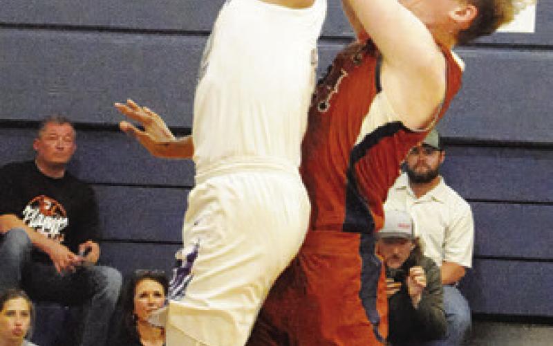 HARRISON NOVAK of Caldwell takes a shot as this Wheatley defender reaches to block it. -- Tribune photo by Denise Squier