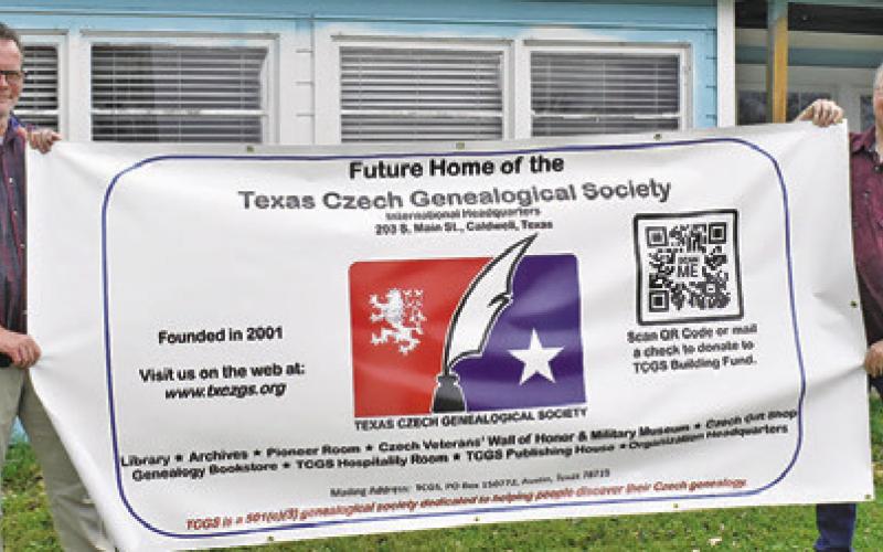 MICHAEL BRYANT AND Patrick Janis display this sign promoting the Texas Czech Genealogical Society’s new home in Caldwell.