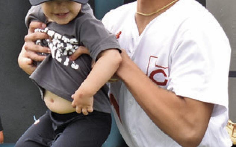KORBIN BURNS holds this future Hornet during Little League Day at Hornet Field. Tribune photo by Roy Sanders