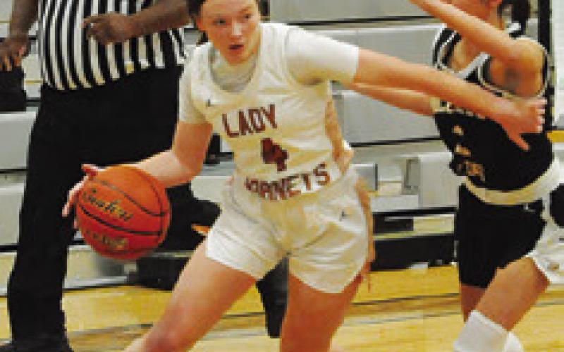 CADIE COSTON dribbles around a Bruceville-Eddy player, driving down the baseline, during Caldwell’s game last Monday.