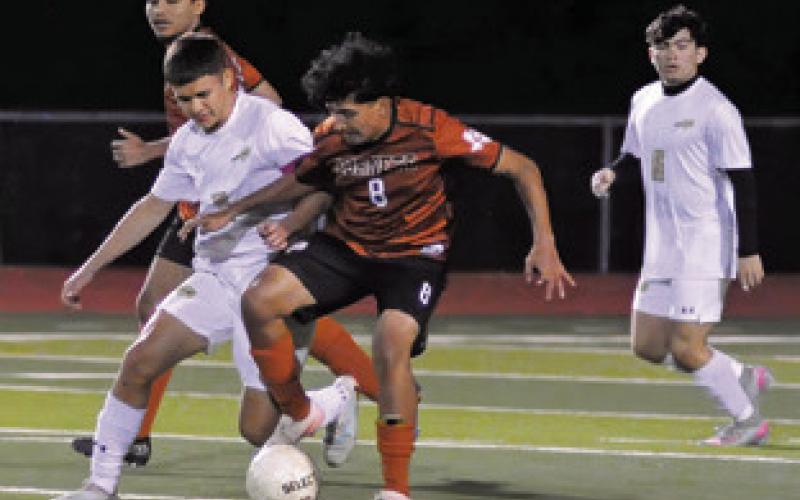 CALDWELL’S JONATHAN SERNA challenges a Giddings player for possession of the ball during Caldwell’s 5-0 loss to the Buffaloes on Friday. Tribune photo by Denise Squier
