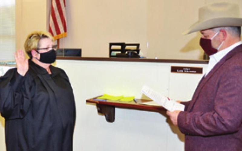 DISTRICT JUDGE REVA Towslee Corbett is sworn into office by Burleson County Judge Keith Schroeder on Jan. 1.