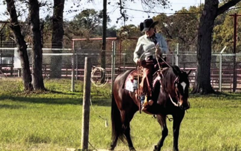 KELLY LAZO AND HER HORSE, The Lil Prince, completing the drag portion of their Limited Amateur Ranch Trail class. Photo courtesy of Kelly Lazo