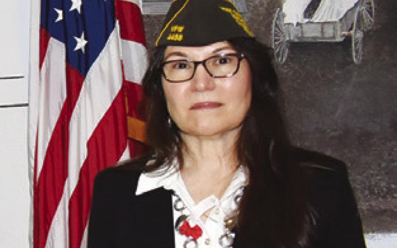 BURLESON COUNTY Service Officer Tina Smith stands next to the American Flag during the Veterans Day ceremony.
