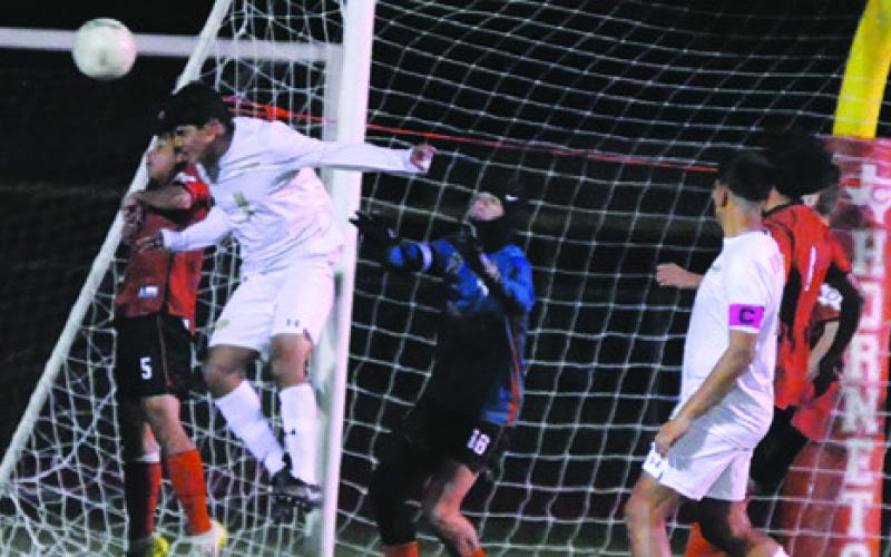 A GIDDINGS’ PLAYER HEADS the ball while the Caldwell goalkeeper keeps a close eye on the direction of the ball in the air during the Hornets’ 5-0 loss to the Buffaloes last Friday night at Hornet Field. Tribune photo by Denise Squier