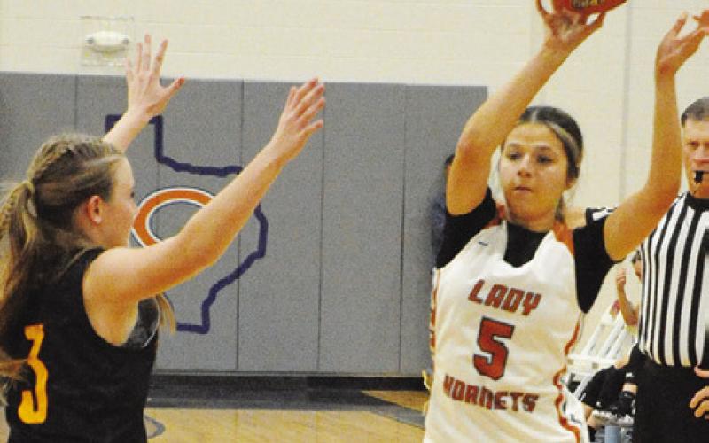 CALDWELL”S ASHLYN KELLUM passes the ball while Thorndale’s Jordyn Smith defends during the Lady Hornet-Lady Bulldog game last Friday night at Hornet Gym. -- Tribune photo by Denise Squier