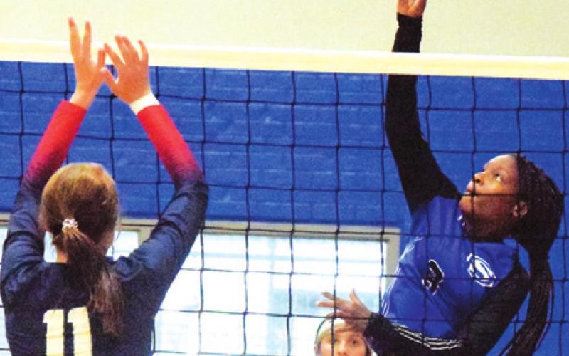 SNOOK’S BRE’ASIA LOUIS hits the ball over Madisonville’s Zaylea Brunette during the Lady Jays’ loss to the Lady Mustangs last Tuesday night in Snook. -- Tribune photo by Denise Squier