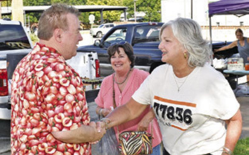 CALDWELL MAYOR JANICE Easter greets TV star Michael Marks, Your Produce Man, at the Farmers Market in downtown Caldwell.