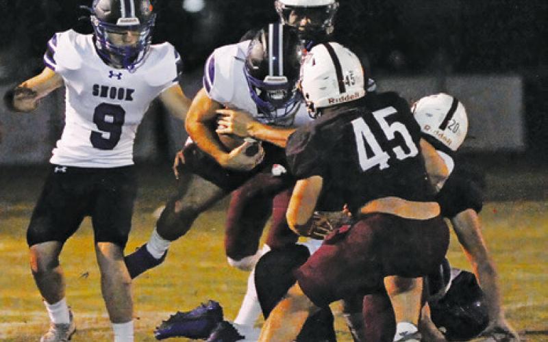 JORDAN PRICE OF Snook carries the ball against Tarkington. Also pictured is teammage Wyatt Lopez. Tribune photo by Denise Squier