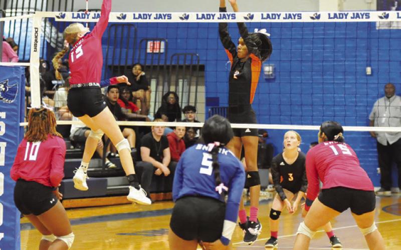 SNOOK’S DAKOTA KIENOW GETS one of her five kills while Somerville’s Karys Ellis attempts a block during the Snook-Somerville rivalry match last Tuesday night in Snook. Tribune photo by Denise Squier