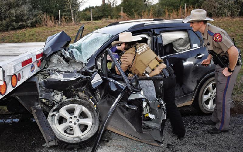 LAW OFFICERS WORK AT this fatal accident on Saturday on State Highway 21 West. Tribune photo by Roy Sanders
