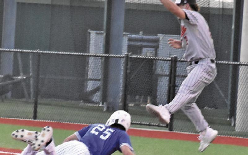 SOMERVILLE FIRST BASEMAN Colt Holton leaps high to catch the ball as this Mumford base runner gets back to first base. Tribune photo by Roy Sanders
