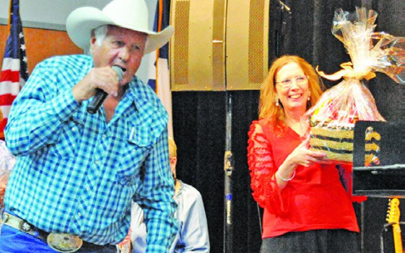 CHARLES DOONAN WAS THE auctioneer for the live auction at Saturday’s “Denim, Dinner &amp;amp; Dancing Gala.” Also picture is Jodi Olive. Tribune photo by Denise Squier