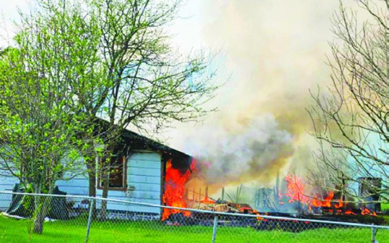 THIS HOUSE ON County Road 349 burns as firefighters arrive. Photo courtesy of Snook Volunteer Fire Department