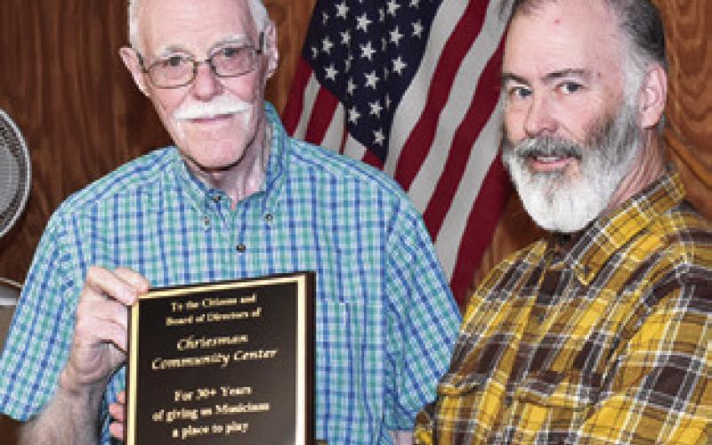 DON LING presents a plaque to Sam Johnson of the Chriesman Community Center honoring the center’s long-time support of live music. The plaque was presented on behalf of the musicians at the center’s Jan. 16 board meeting. Tribune photo by Roy Sanders