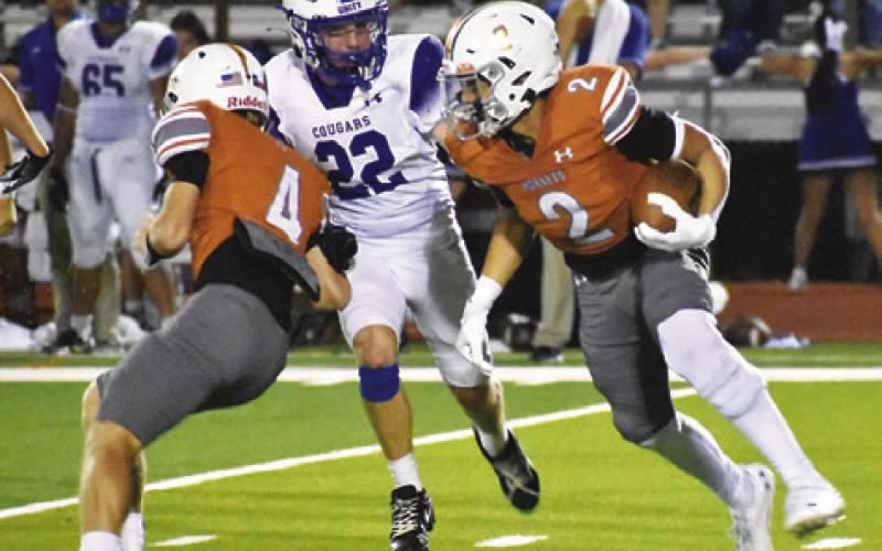 KORBIN BURNS CARRIES the ball as Peyton Braden blocks.