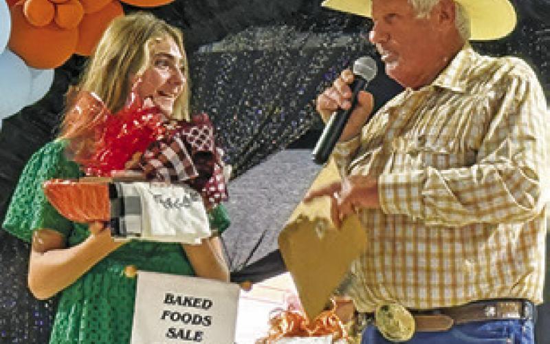 CARSON EVERS and Charles Doonan converse during the Baked Foods Sale on Sunday. Evers brought in the highest bid of $5,000 for her Snickerdoodle Bread. Tribune photo by Denise Squier