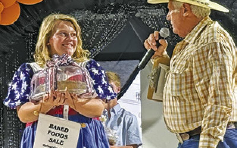 MARLEY KOCUREK has a conversation on stage with Baked Foods Sale auctioneer Charles Doonan on Sunday. Tribune photo by Denise Squier