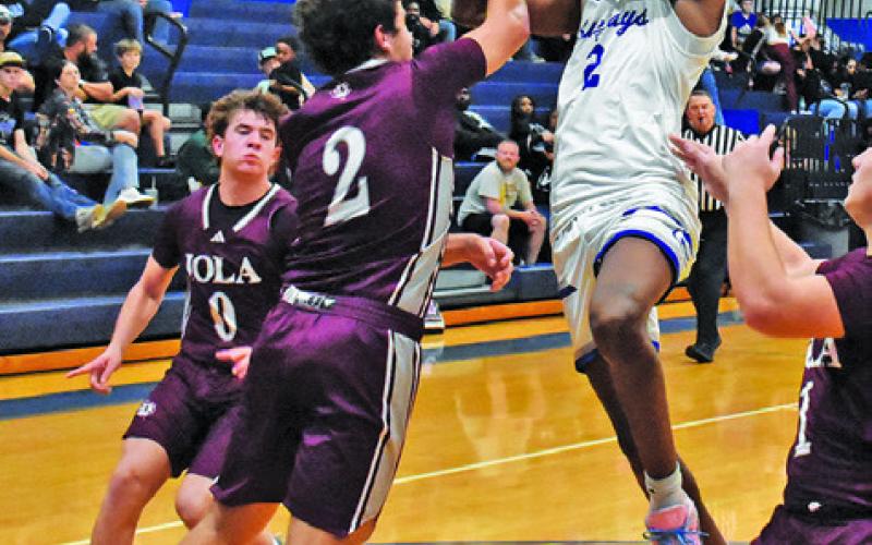 JIMMY KEARNEY OF SNOOK shoots despite heavy pressure from the Iola defense. Tribune photo by Roy Sanders
