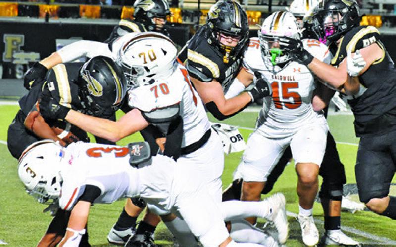 THE HORNET DEFENSE led by R.J. King, Caden Schluens and Josh Wilson move in on this Giddings ball carrier last Friday. Tribune photo by Roy Sanders