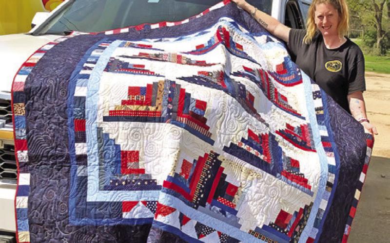 CREATIVE MEMORIES QUILT Guild donated this quilt to the Cade Lake VFD for their Annual Barbecue Fundraiser on March 10. Pictured is Melissa Triplett picking up the quilt.