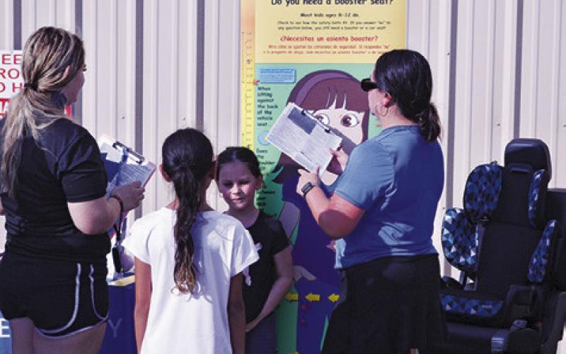 AREA STUDENTS WERE ABLE to see if they needed a new booster seat last week’s “Back-to-School Bash.” Tribune photo by Kimberly Hutcheson