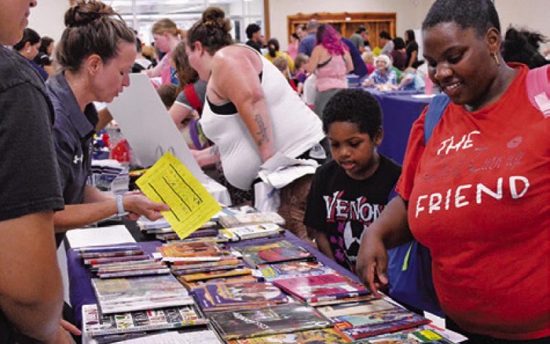 BURLESON COUNTY STUDENTS were able to take home books, given by the Harrie P. Woodson Memorial Library at last week’s “Back-to-School Bash.” Tribune photo by Kimberly Hutcheson