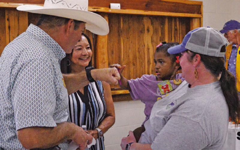 BURLESON COUNTY SHERIFF Bill Rios fist bumps this child in all the excitement of last week’s “Back-to-School Bash.” Tribune photo by Kimberly Hutcheson