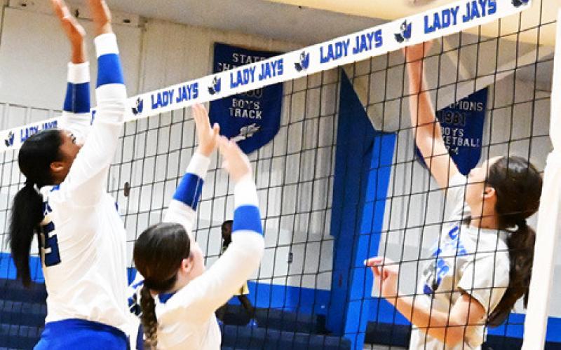 ASSISTANT LADY JAY coach Riley Green hits the ball over two Lady Jays during Friday’s alumni scrimmage. Green is a former Lady Jay volleyball player and a new addition to the Snook coaching staff. Tribune photo by Denise Squier