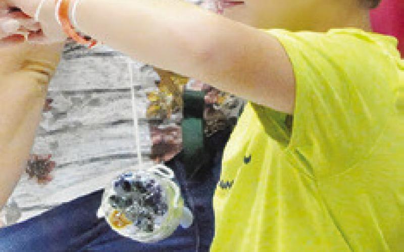 THIS CHILD FINISHED building his bee hotel out of a water bottle and paper during last Thursday’s “The Un-bee-lievable life of bees” event hosted by the Harrie P. Woodson Memorial Library. Tribune photo by Denise Squier