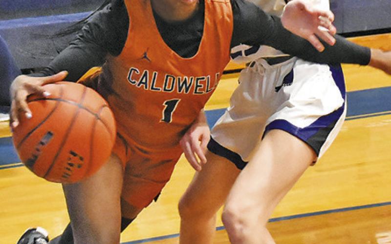AMOREE DENSON dribbles along the baseline and around Dakota Kienow during the Snook-Caldwell game last Friday night.