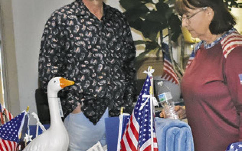 AUCTION ITEMS are displayed and viewed on Saturday at the July 4 celebration at the Hermann Sons Life Hall in Deanville.