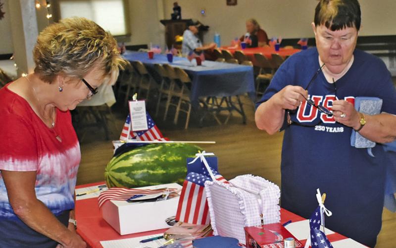 AUCTION ITEMS ARE examined on Saturday, July 4, at the Hermann Sons Life Hall as part of their America 250 celebration.