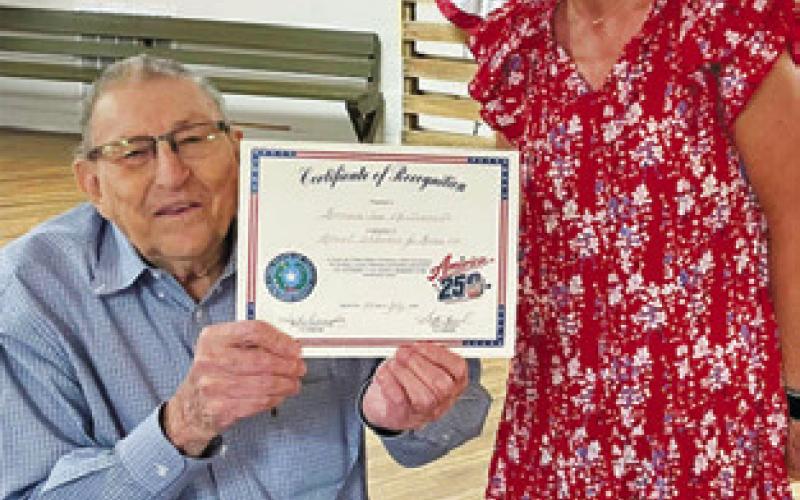 AMY JURICA OF the Burleson County Historical Commission presents this certificate of recognition to Hermann Sons Life in Deanville, accepted by President Donnie Blinka, as part of the organization’s America 250 celebration last Saturday.