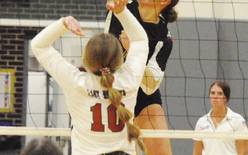 GIDDINGS’ FAITH ZOCH gets a kill against the Lady Hornets while Caldwell’s Kelly Urbanovsky attempts a block during the Lady Buffs’ straightset district victory at Hornet Gym in Caldwell on Friday. Also pictured is Brooklyn Snider. -- Tribune photo by Denise Squier