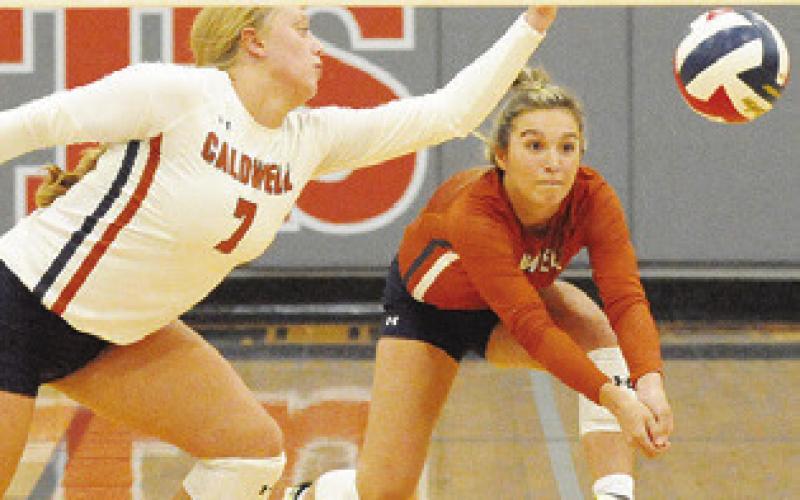 CALDWELL’S CAITLYN FAUST and Ciara Coker dive for the ball during the Lady Hornets’ district match against Giddings on Friday.