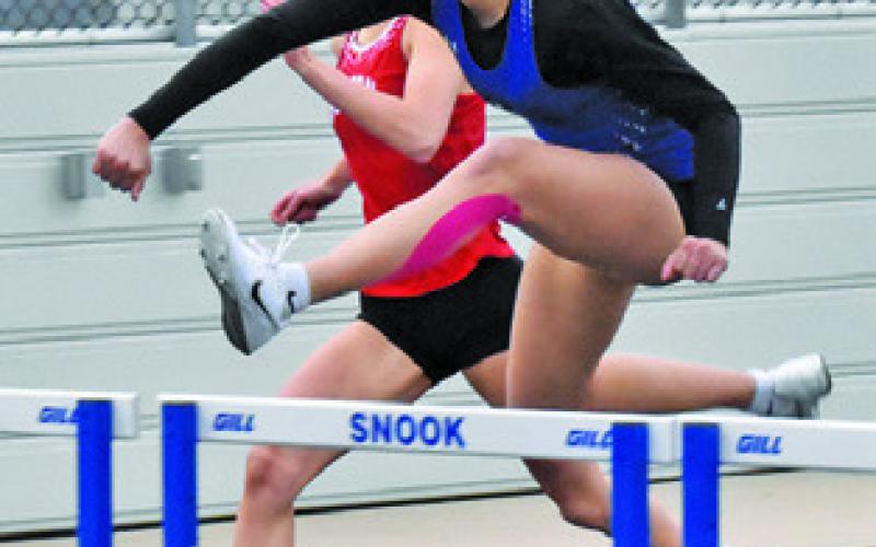 SNOOK’S JADE Lauderdale jumps over a hurdle during the Bluejay Relays last week. Tribune photo by Roy Sanders