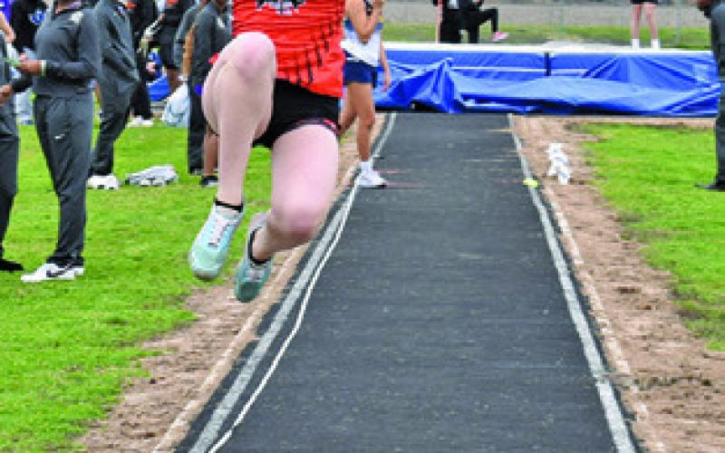 VICTORIA MYERS leaps for distance during field events at last week’s Bluejay Relays. Tribune photo by Roy Sanders