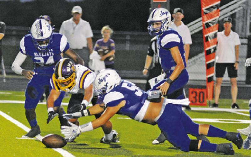 SNOOK’S RICHARD SANTILLAN reaches for this fumble as teammates Mark Moore and J. Beaux Hruska watch. Snook rallied in the second half to win 20-13. -- Tribune photo by Denise Squier
