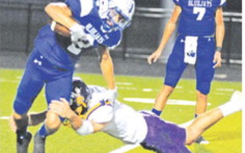 SNOOK’S LANCE LARA carries the ball as this Weimar defender moves in for a tackle. Also pictured is teammate J. Beaux Hruska. Snook won the game 20-13. -- Tribune photo by Denise Squier