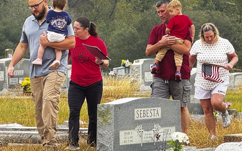 ENTIRE FAMILIES PARTICIPATED in placing U.S. flags on veterans’ graves in the Snook Cemetery on Saturday morning, in observance of Veterans Day. Tribune photo by Denise Squier