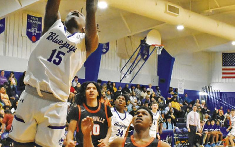 Gardner Shivers approach the basket. -- Tribune photo by Roy Sanders SNOOK’S BUD MOORE shoots as Somerville’s KeKe Daniels and