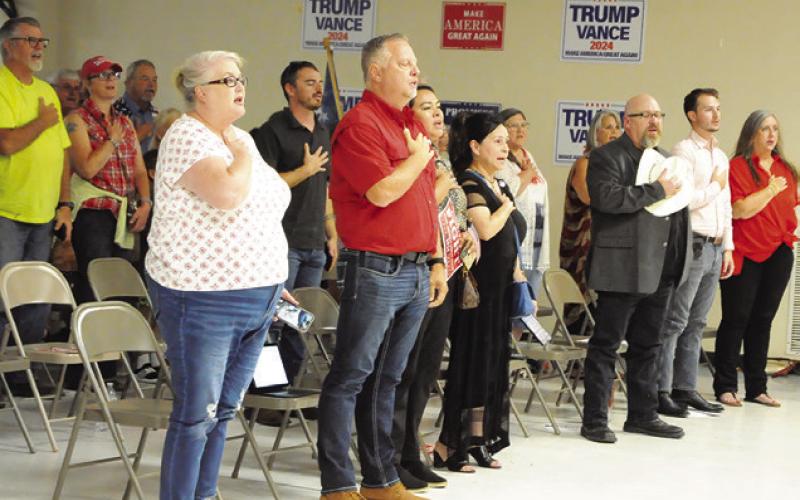 PEOPLE ATTENDING THE MAGA/Trump Rally last Thursday say the Pledge of Allegiance. Tribune photo by Denise Squier
