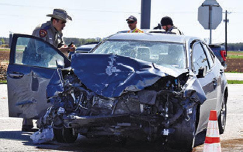 A DPS TROOPER works the site of this car-pickup collision on Sunday afternoon, March 16, at the F.M. 50 and F.M. 60 intersection. No details were available at press time. Tribune photo by Roy Sanders