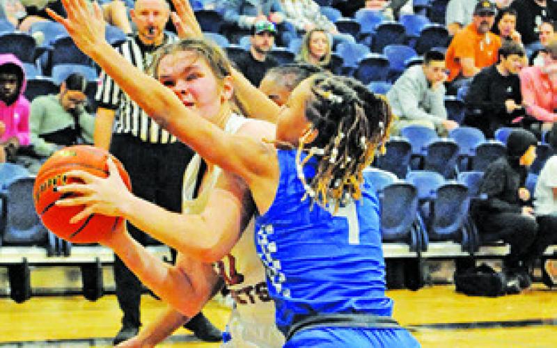 RILEY BROADDUS tries to find the basket as Anaya Fowler defends during the Caldwell-New Tech game last Tuesday night.